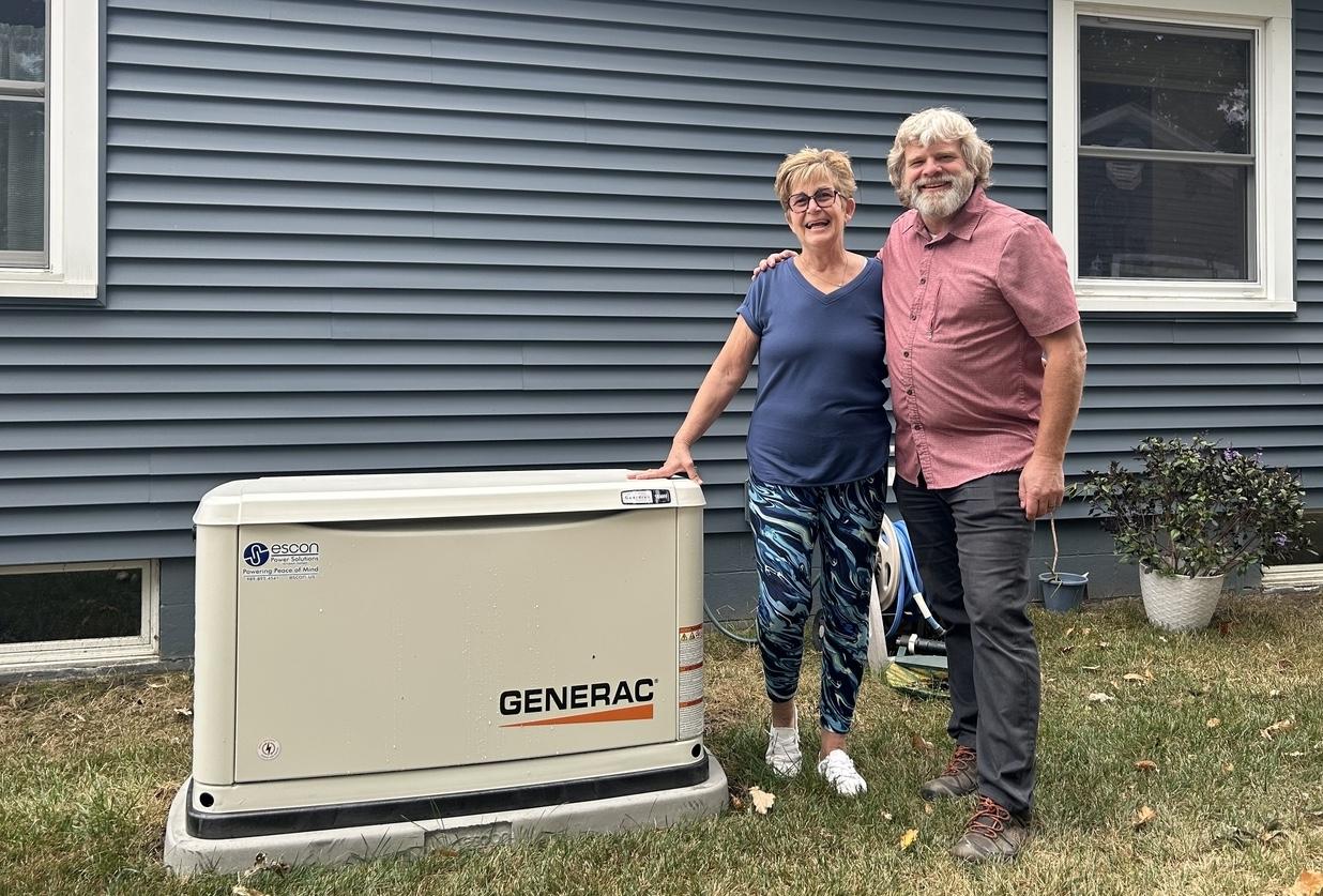 Homeowners beside their new Generac standby generator installed by ESCON Power Solutions